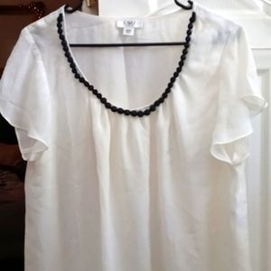 White shirt with black beads around low neck line